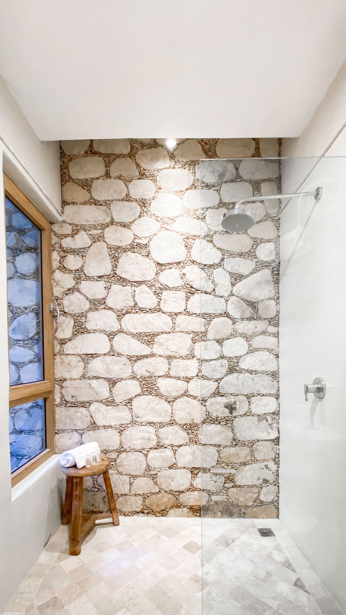 Modern Stone Wall Bathroom Shower Design — featured photo for “Should You Caulk Around the Base of a Toilet?”